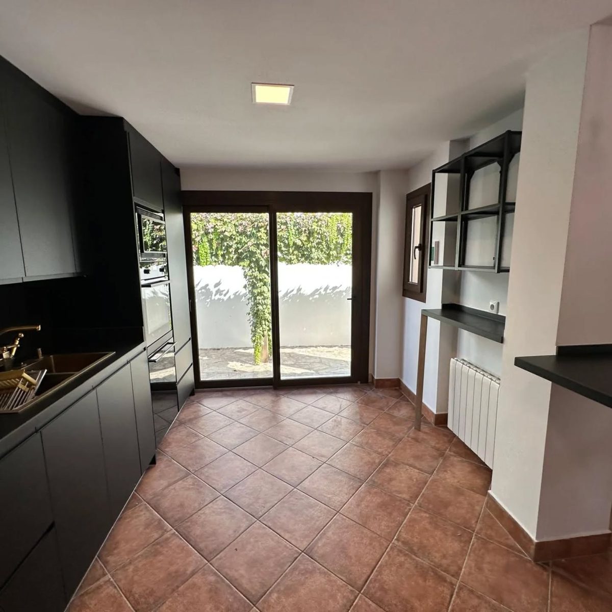 Puerta-ventana y ventana abatible en una cocina, con salida al patio