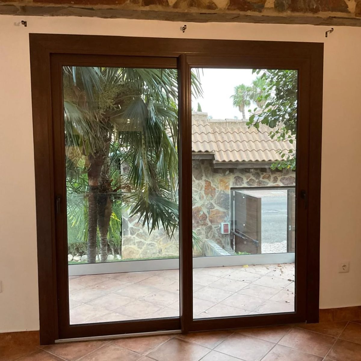 Corredera de dos hojas con acabado imitación madera abierta al jardín