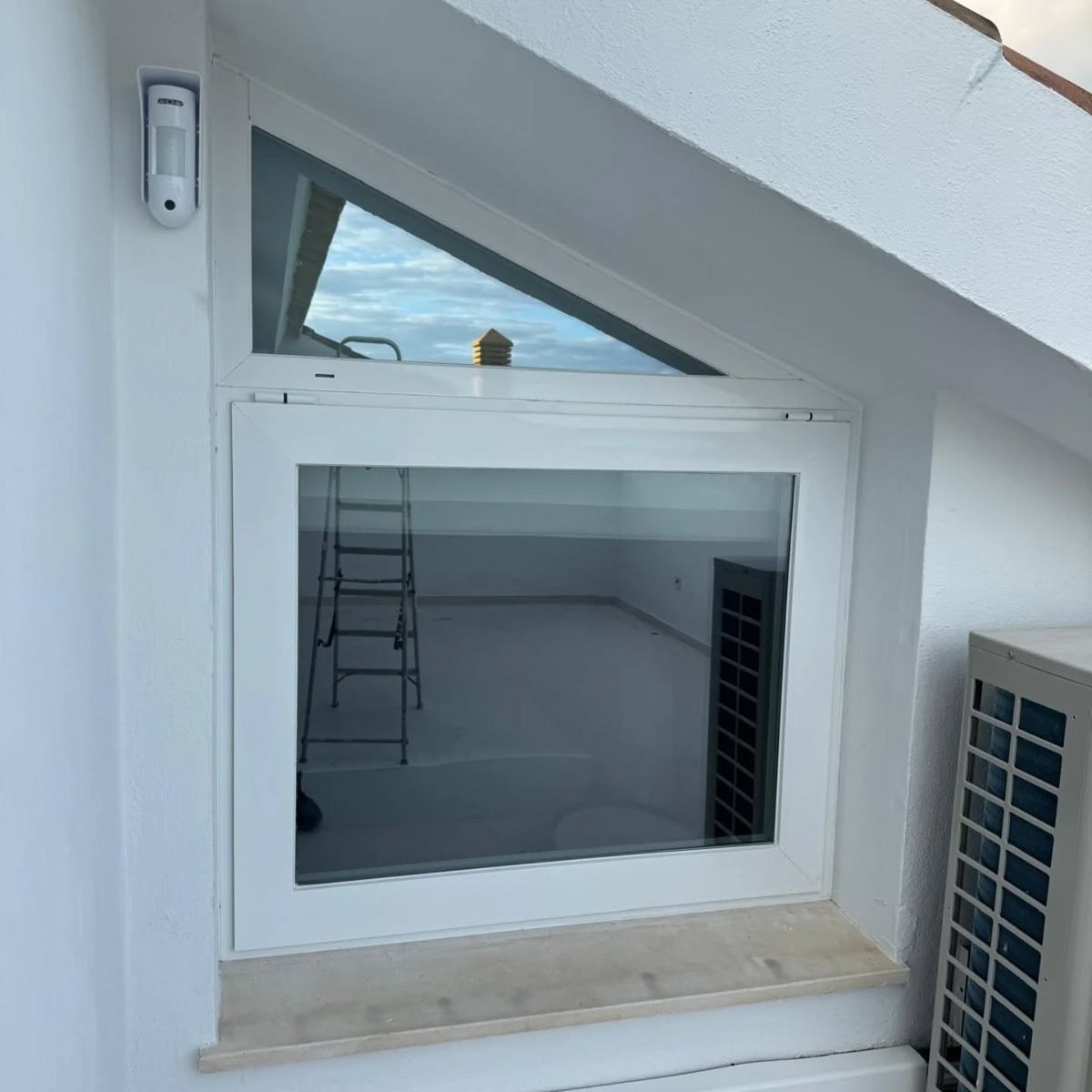 Ventana fabricada a medida para un hueco triangular bajo la pendiente del tejado